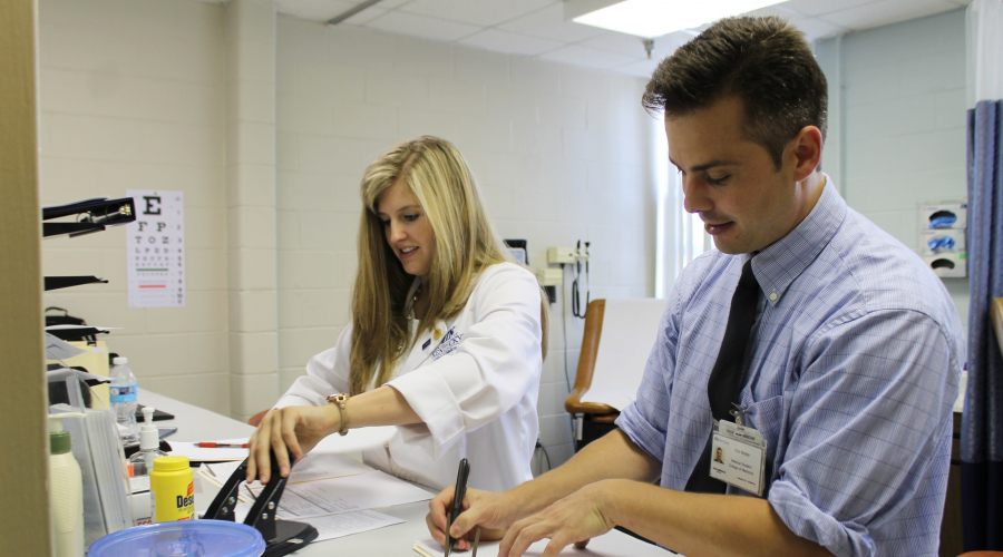 two medical students preparing intake paperwork
