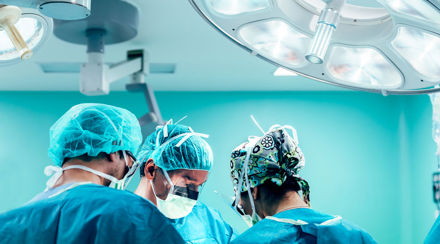 three surgeons in operating theatre