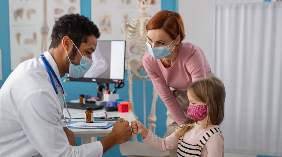 doctor giving a young girl a fist bump