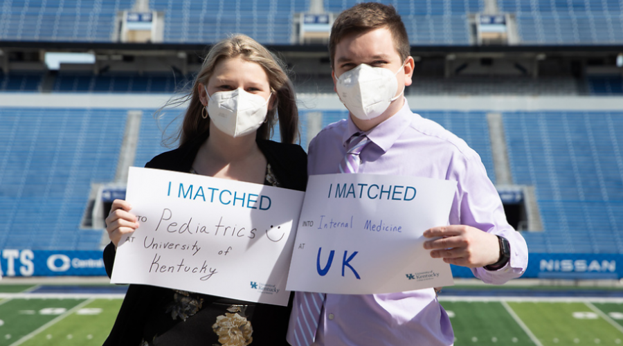 two College of Medicine students holding signs indicating where they matched for their residencies