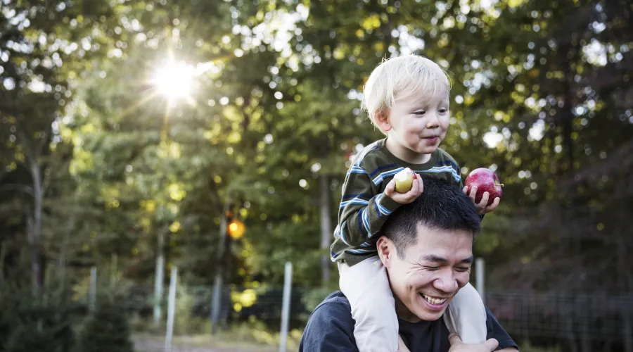 kid sitting on the shoulders of parent