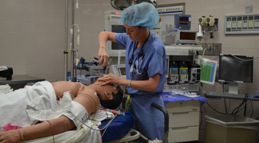 Anesthesiologist resident or fellow in simulation training with human mannequin on table
