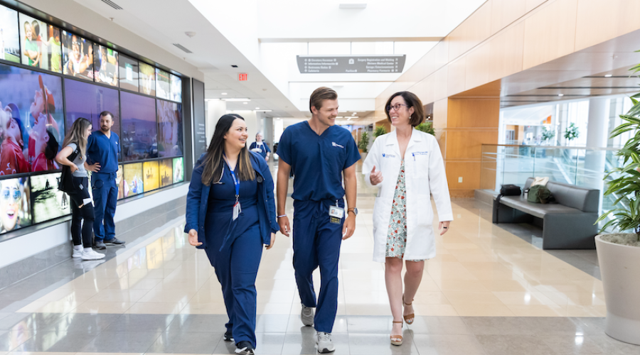 faculty, student, and resident walking together in the hospital