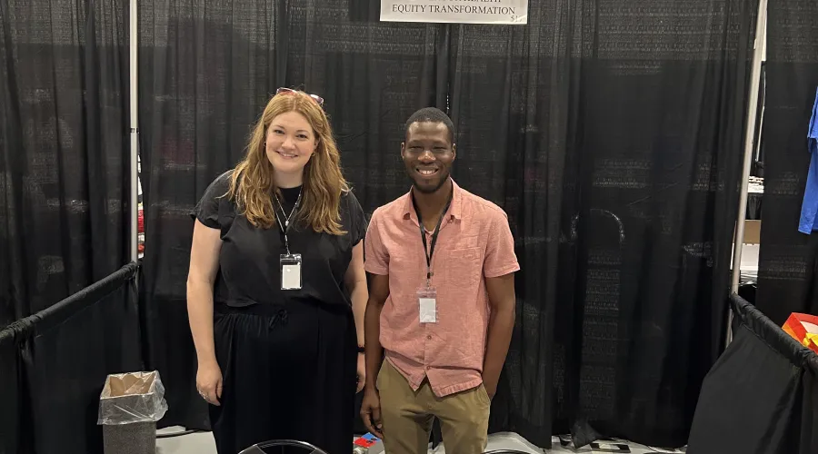 CHET graduate students standing behind table