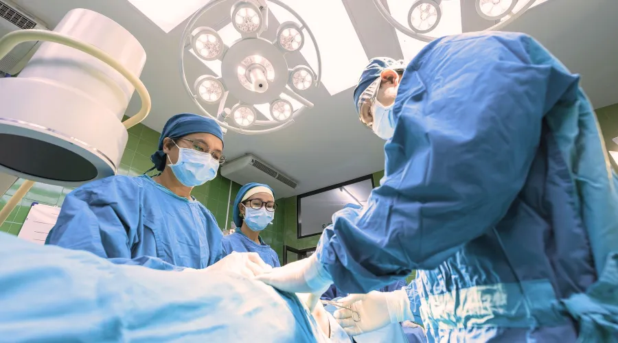 A group of surgeons over a hospital bed
