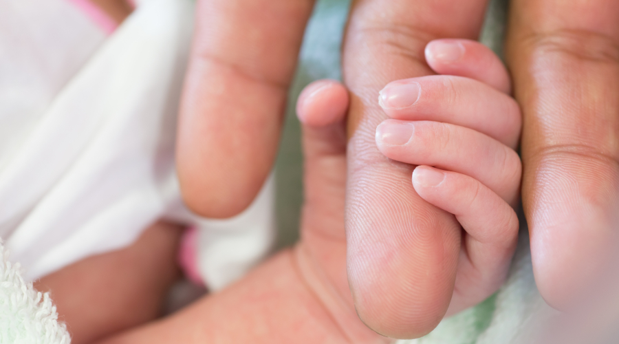 newborn hand holding finger