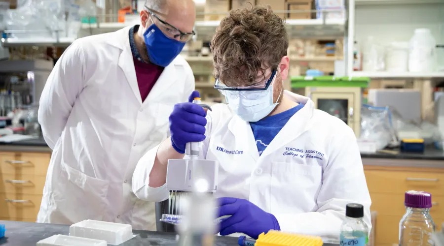 a professor helping a research student with lab work