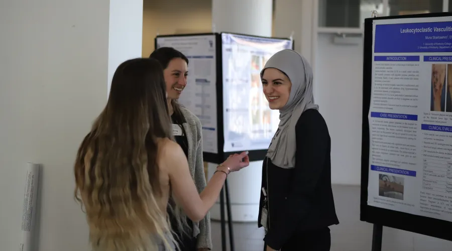 students standing talking in front of research posters