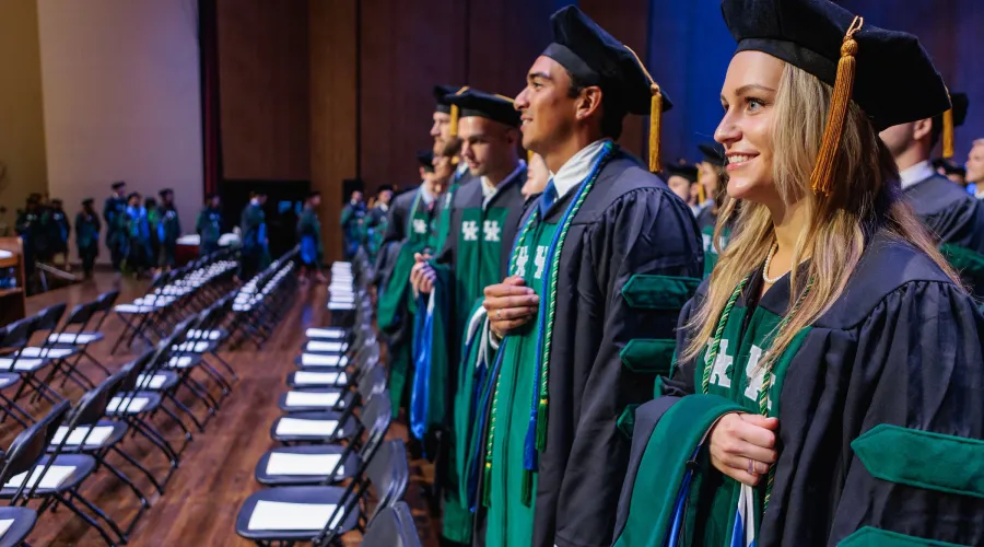 students standing on stage during their graduation ceremony