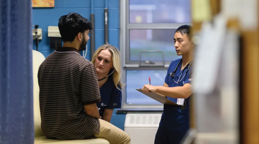 Salvation Army Clinic student listening to a patient's heart.