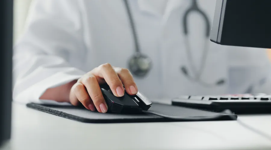 doctor in white coat at a desktop computer