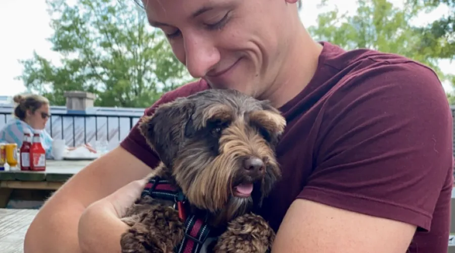 ophthalmology resident david templeton holding a dog in his arms