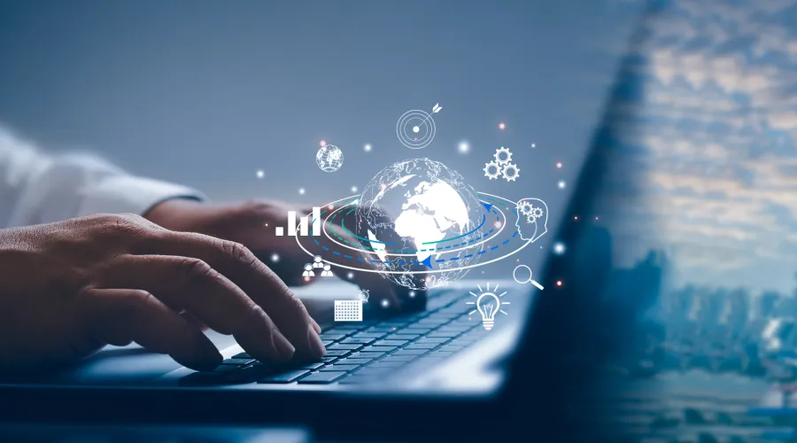 A close up of someone typing on a computer. Small graphics of the earth hover in white over the computer.