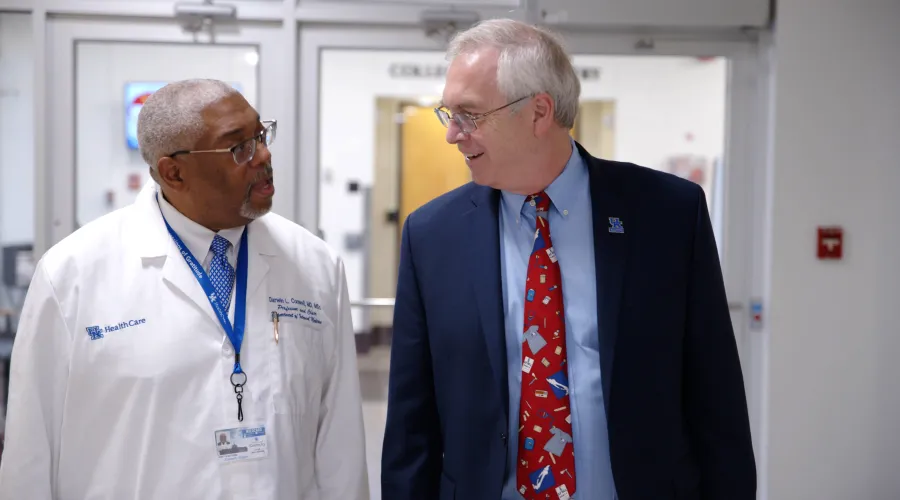 Dean Griffith and Chair Conwell walking and talking together. Dean Griffith is smiling.