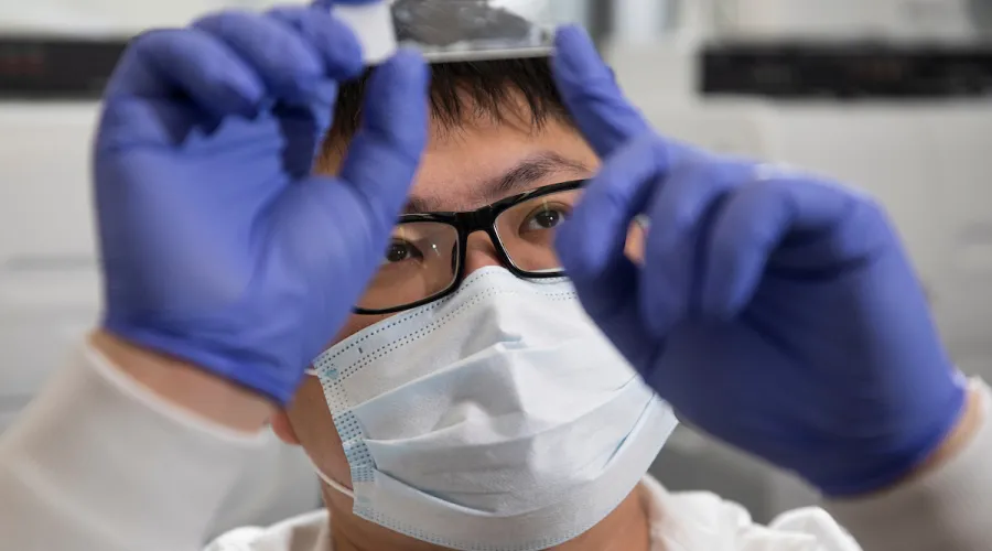 Close up of male scientist studying a slide. 