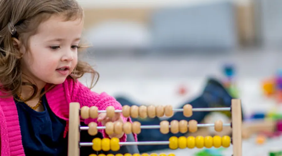 little girl plays with counting beads