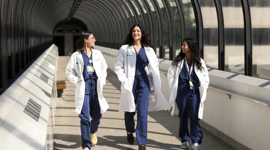 Three medical professional walking and talking 