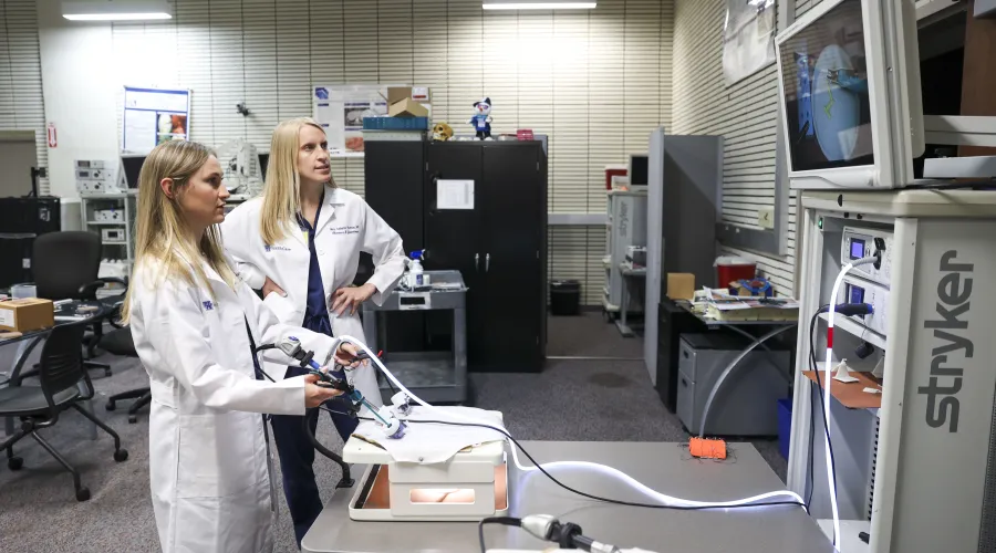 Two medical professionals training on a simulation device 