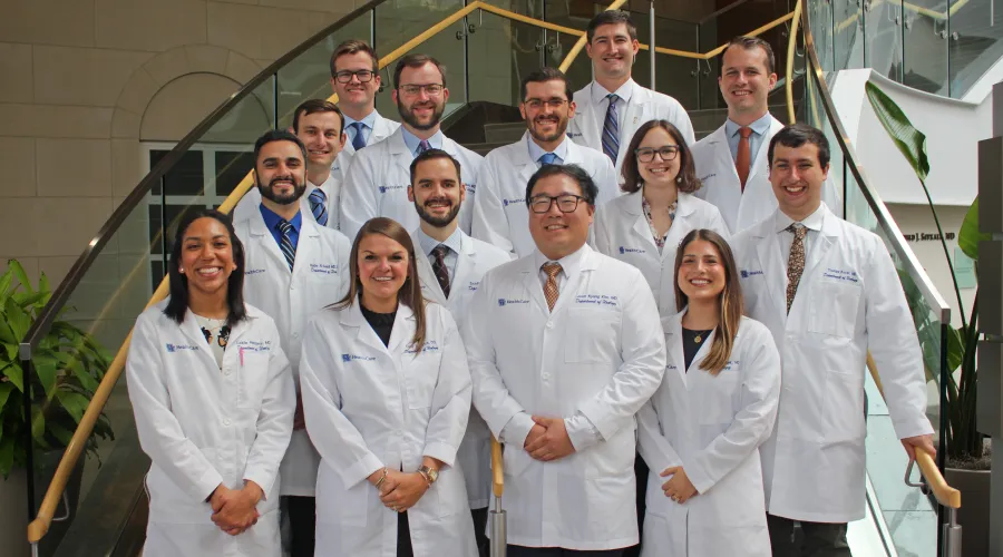 Urology residents group photo in white coats on staircase