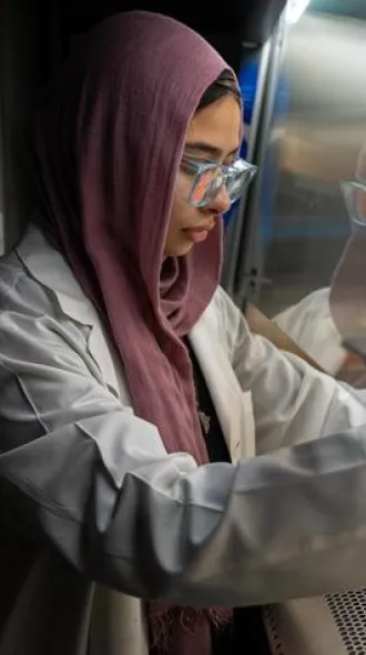 Elaf Ghoneim working in a UK laboratory under a hood ventilator.