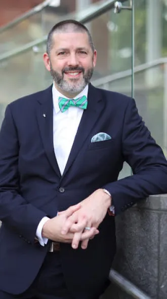 Matthew Bush posed for a photo while leaning on a railing.