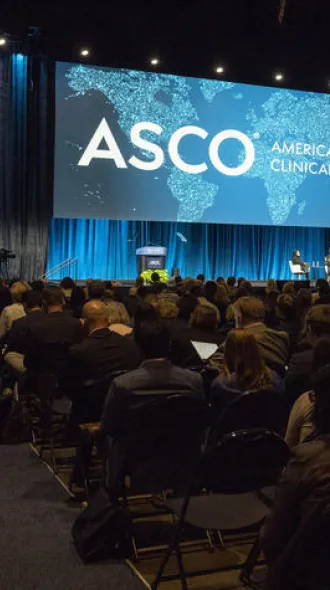 The auditorium of people facing the stage for ASCO - American Society of Clinical Oncology