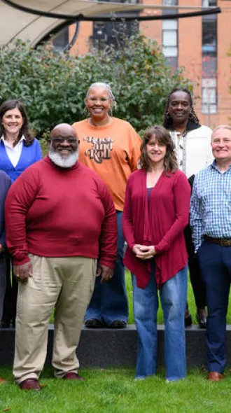 Members of UK Markey Cancer Center’s Community Advisory Board standing against farm fencing.