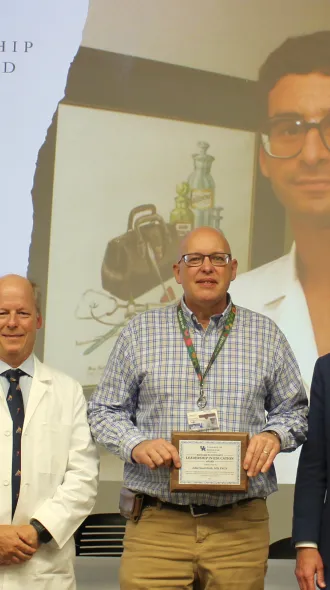 Dr. William B. Inabnet, Department of Surgery Chair (Left) and Dr. Andrew Bernard, Division Chief and previous Schwartz Award winner, present Dr. John Roth with the Schwartz Award Lifetime Achievement Award for Teaching