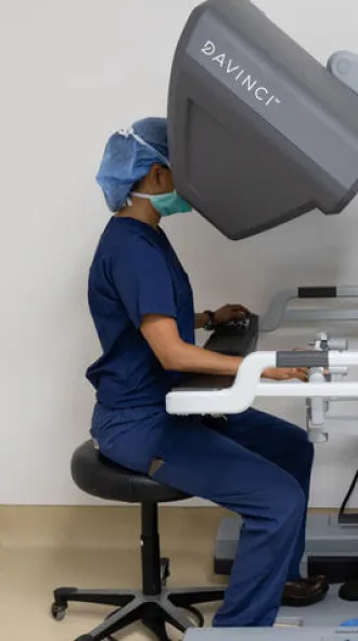 At a control console in the operating room, Shah guides surgical tools through a single, three centimeter incision.