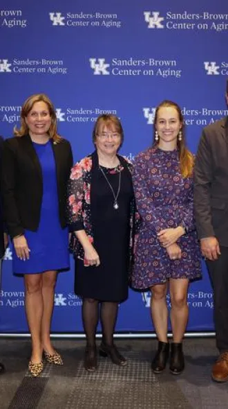 From left: Britt Brockman, Kentucky Sen. Amanda Mays Bledsoe, Linda Van Eldik, Mallory Martinez, Kentucky House Majority Floor Leader Steven Rudy and Eli Capilouto standing in front of a Sanders-Brown Center on Aging banner wall.