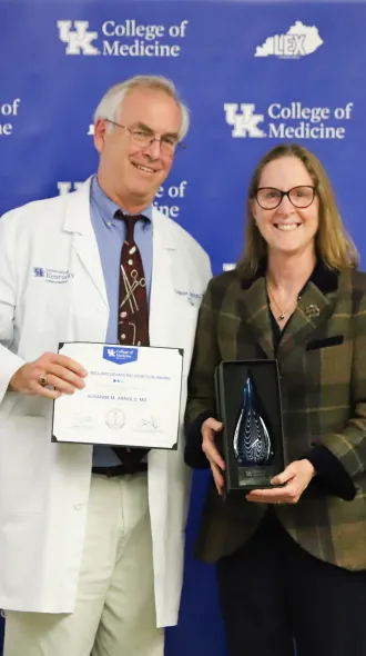 Dr. Griffith and Dr. Arnold pose for a photo in front of a blue background