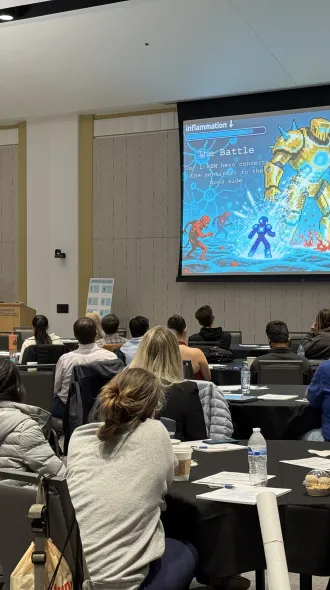 Audience members look on as a poster pitch is given. 