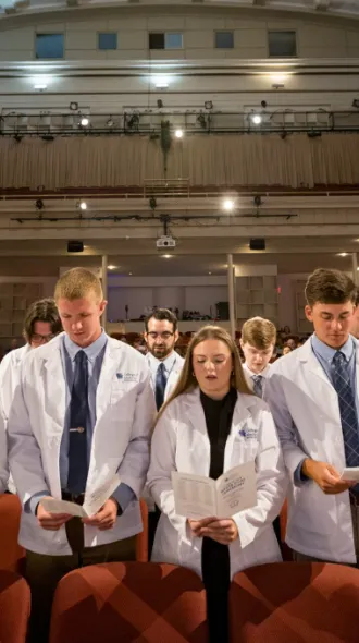 Large group of students reciting pledge during white coat ceremony