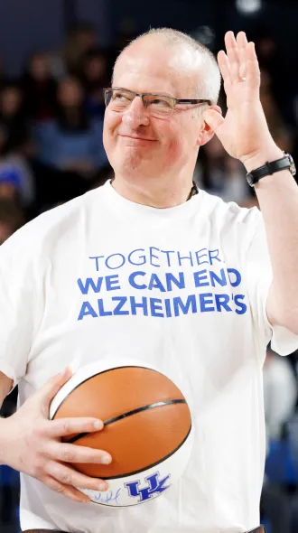 Dr. Pete Nelson, holding basketball,  is honored at the "We Back Pat" UK Women's Basketball game