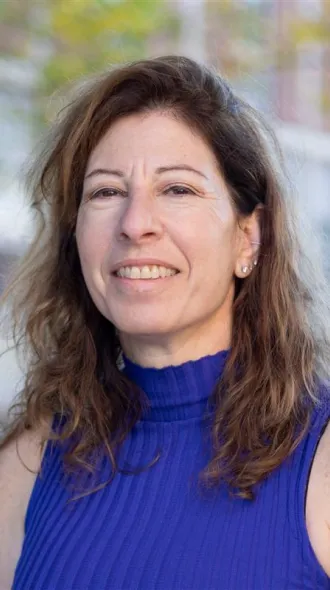 portrait of dr. bonnie firestein, woman with shoulder-length brown hair and blue top
