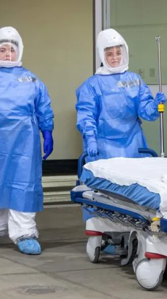 UK HealthCare Infection Prevention and Control Medical Directors Nicholas Van Sickels, far left, and Takaaki Kobyashi, far right, oversee intake of the pretend patient during the drill.