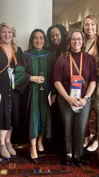 Preet Datta stands with others holding a glass of champagne