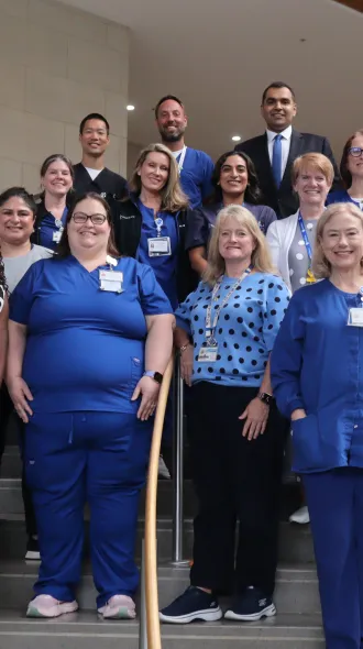 The A2F ICU liberation workgroup stand on stairs in a group, smiling